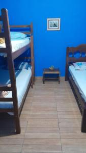 um quarto com 2 beliches e uma parede azul em Casa e camping Reinaldo e Julia recanto das árvores em Itamonte