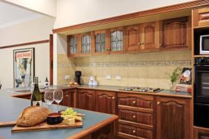 een keuken met houten kasten en een bar met wijnglazen bij Grand View with Spa & Sauna in Warburton
