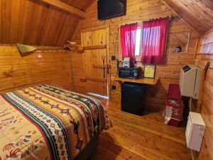 una camera da letto con un letto in una cabina di legno di Kingman KOA a Kingman