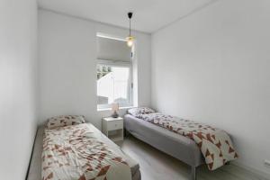 a bedroom with two beds and a window at Aalesund centrum apartement. in Ålesund