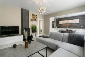 a living room with a couch and a television at Aalesund centrum apartement. in Ålesund