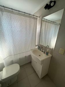 La salle de bains est pourvue de toilettes, d'un lavabo et d'un miroir. dans l'établissement Excelente departamento con ubicación ideal, à Buenos Aires