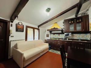 a living room with a couch and a kitchen at [FREE PARKING] La Bianca Neve Cottage in Castel di Sangro