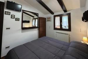 a bedroom with a bed and a tv on the wall at [FREE PARKING] La Bianca Neve Cottage in Castel di Sangro