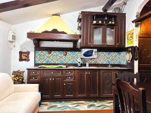 a kitchen with wooden cabinets and a counter top at [FREE PARKING] La Bianca Neve Cottage in Castel di Sangro +3 photos