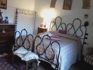 1 dormitorio con 1 cama grande con colcha blanca en Cisterna Nel Borgo en Castiglione dʼOrcia