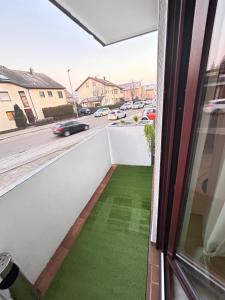 a balcony with a green floor and a view of a street at Wikinger Apartment Felicia in Ostfildern