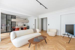 sala de estar con sofá blanco y TV en Luxury Living in Trocadéro en París