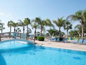 a swimming pool at a resort with palm trees at Anmaria Beach Hotel & Spa in Ayia Napa