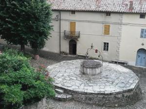 a stone circle in front of a white building at Cisterna Nel Borgo in Castiglione dʼOrcia