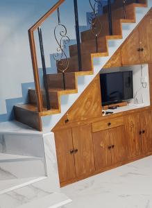a living room with a tv under a staircase at JB Home sweet home Perfect for Family & Friends in Babag