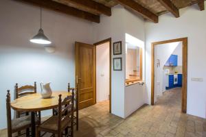 cocina y comedor con mesa de madera y sillas en Ca la Roseta, en Sant Pere Pescador