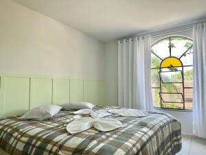 - une chambre blanche dotée d'un lit avec oreillers et d'une fenêtre dans l'établissement Suíte na casa amarela, à Pomerode