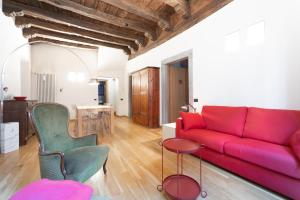 een woonkamer met een rode bank en een tafel bij La Dimora dei Mercanti in Bergamo