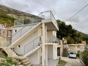 ein weißes Gebäude mit einer Treppe und einem Balkon in der Unterkunft Sutomore Panorama Apartment in Sutomore