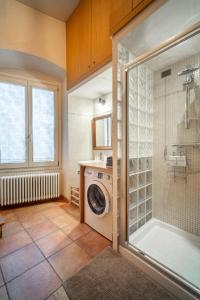 een badkamer met een douche en een wasmachine bij La Dimora dei Mercanti in Bergamo