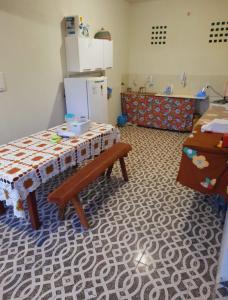 a kitchen with a table and a refrigerator at ITAÚNAS Pousada Nossa Palhoça in Itaúnas +17 photos