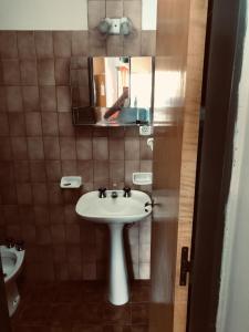 y baño con lavabo y espejo. en Complejo Altas Cumbres en Villa Cura Brochero