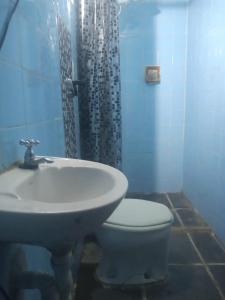 a bathroom with a sink and a toilet and a shower at Quarto em Caraguatatuba litoral norte in Caraguatatuba