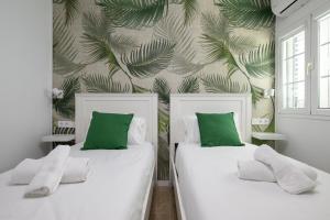 2 Betten in einem Zimmer mit grünen und weißen Kissen in der Unterkunft Beachside hideaway Gran Canaria in San Bartolomé de Tirajana + 18 Fotos