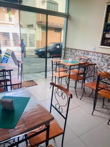 a group of tables and chairs in a restaurant at Pousada Familia Aparecida in Aparecida