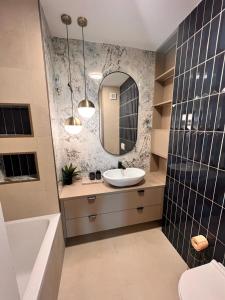 Cluj Rozelor Apartament 88 في كلوي نابوكا: حمام مع حوض ومرآة وحوض استحمام