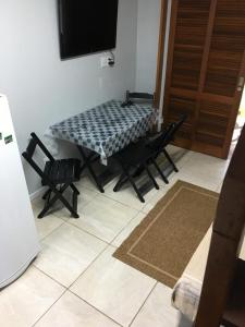 Cette chambre dispose d'une table, de chaises et d'une télévision. dans l'établissement Sobrados Varuna, à Passo de Torres