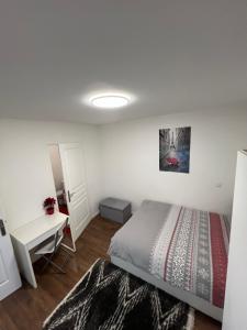 a white bedroom with a bed and a desk at 2 PIECES proche du centre PARIS 15 min in Rosny-sous-Bois