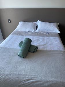 a white bed with two stuffed animals on it at Apto inteiro 2 quartos, condomínio com piscina aquecida in Bombinhas