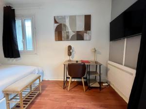 a bedroom with a desk and a bed and a bed and a table at Appartement Proche de Disneyland & Paris in Noisy-le-Grand
