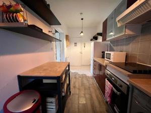 una pequeña cocina con mesa y microondas en Appartement Proche de Disneyland & Paris, en Noisy-le-Grand
