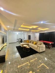 a living room with a couch and a ping pong table at Luxury 3BR + 3.5bath apartment in Victoria Island with pool in Lagos