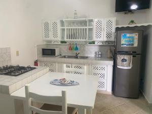 uma cozinha com uma mesa e um frigorífico em La Dolce Vita Rental, Las Terrenas, Samana em Santa Bárbara de Samaná