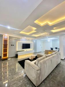 a living room with a couch and a flat screen tv at Luxury 3BR + 3.5bath apartment in Victoria Island with pool in Lagos