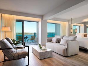 una camera con letto e un soggiorno con divano di NIKO Seaside Resort MGallery ad Ágios Nikólaos
