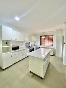 a kitchen with white cabinets and a white counter top at Luxury 3BR + 3.5bath apartment in Victoria Island with pool in Lagos