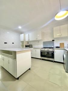 a large kitchen with white cabinets and a stove at Luxury 3BR + 3.5bath apartment in Victoria Island with pool in Lagos
