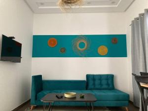 a living room with a blue couch and a table at Diamant de la marsa plage in La Marsa