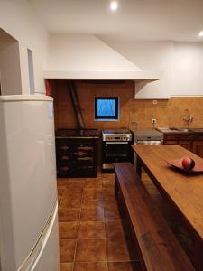 a kitchen with a wooden table and a refrigerator at Amarante Residence in Amarante