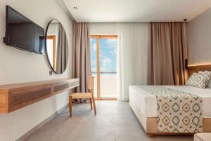 a hotel room with a bed and a mirror at Blue Sea Island in Kolymbia