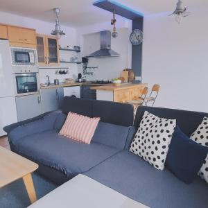 sala de estar con sofá azul y cocina en Casa Faro de Arinaga, en Arinaga