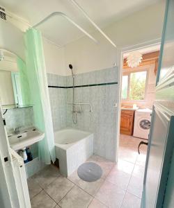 La salle de bains est pourvue d'une baignoire et d'un lavabo. dans l'établissement Appartement familial à Paris, à Villejuif