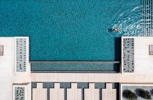 an overhead view of a swimming pool with blue water at Cap St Georges Hotel & Resort in Peyia