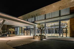 a building with a tree in front of it at night at Cap St Georges Hotel & Resort in Peyia