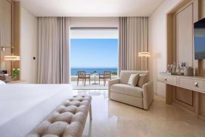 a hotel room with a bed and a view of the ocean at Cap St Georges Hotel & Resort in Peyia