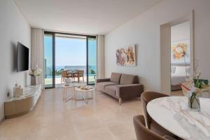 a living room with a couch and a table at Cap St Georges Hotel & Resort in Peyia