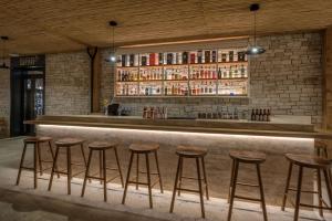 a bar with stools in front of a brick wall at Cap St Georges Hotel & Resort in Peyia