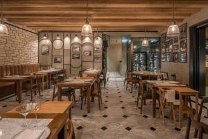 a dining room with wooden tables and chairs at Cap St Georges Hotel & Resort in Peyia
