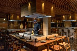 a man standing in a kitchen in a restaurant at Cap St Georges Hotel & Resort in Peyia