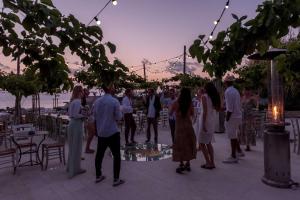 a group of people standing around at a party at Cap St Georges Hotel & Resort in Peyia